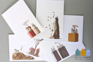 A packaged set of six artistic greeting cards showing miniature paper house sculptures by Betty Pepper.